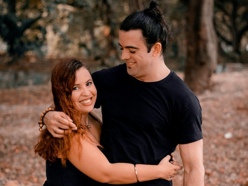 man in black crew neck t-shirt hugging woman in black dress