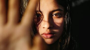 a young woman making a hand gesture with her right hand