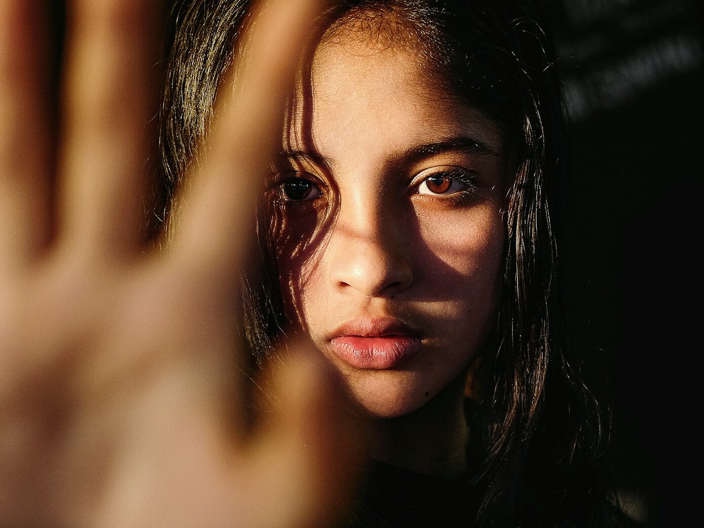 a young woman making a hand gesture with her right hand
