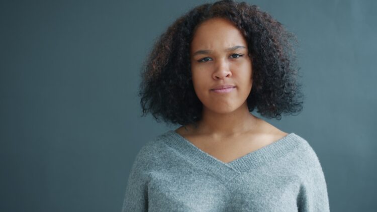A young woman with curly hair looking forward