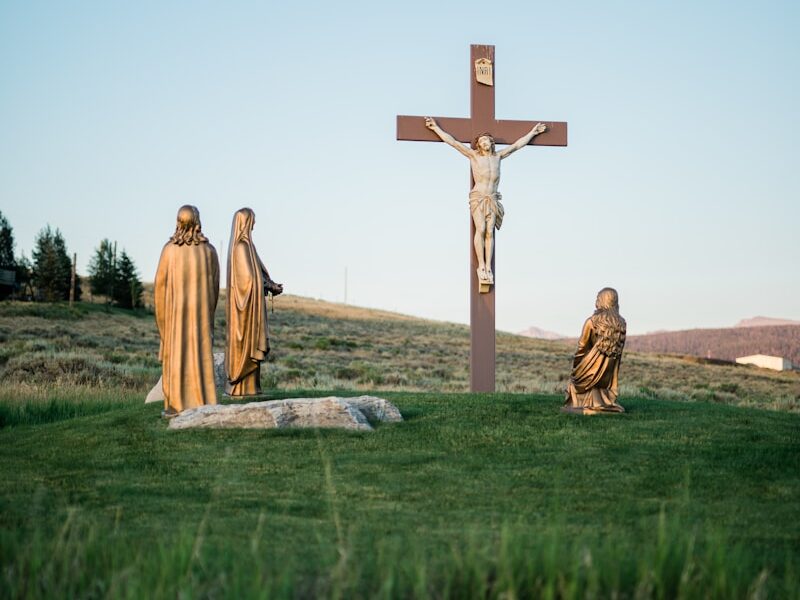 Crucifix statue on green grass