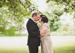 man and woman kissing on green grass field during daytime