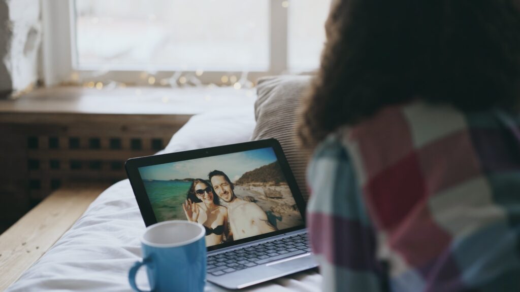 Woman video calls with couple on beach