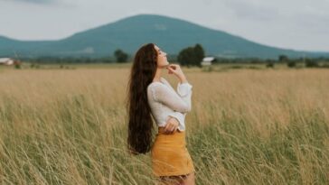 woman standing in the middle of grass field