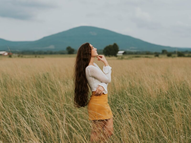 woman standing in the middle of grass field