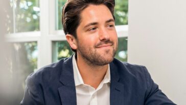 man in black suit jacket holding pen