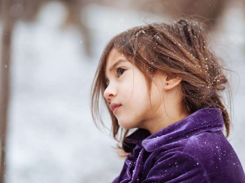 girl wearing purple jacket across blurry background