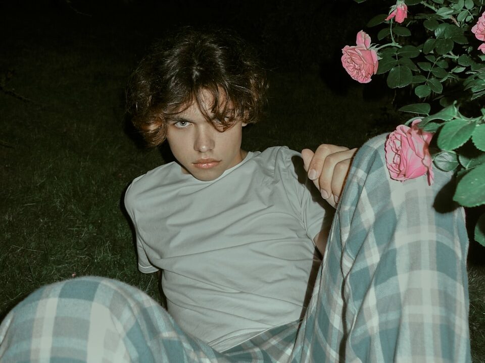 girl in gray long sleeve shirt lying on blue and white plaid textile
