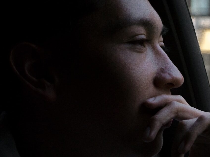 close-up photo of man looking outside vehicles window