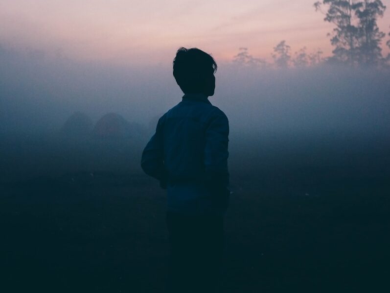 a man walks alone in the haze