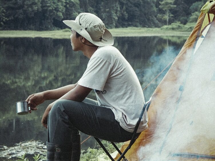 man in cowboy hat sitting on folding chair