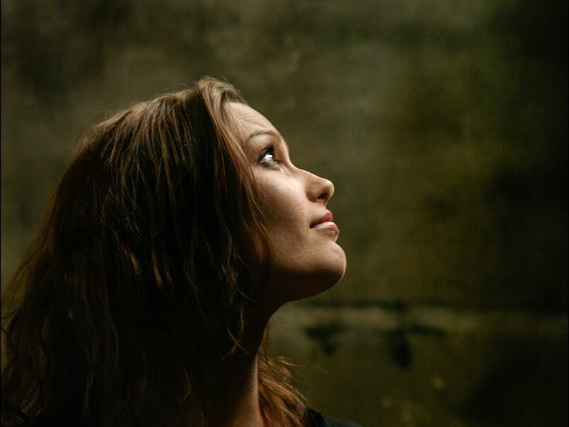 Elegant side profile of brunette woman looking upwards in a contemplative mood.