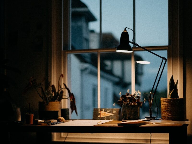 a window with a lamp and a table with objects on it