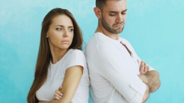 Couple standing back to back with arms crossed