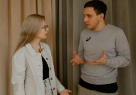 A young couple passionately discussing indoors, capturing intense emotions and gestures.