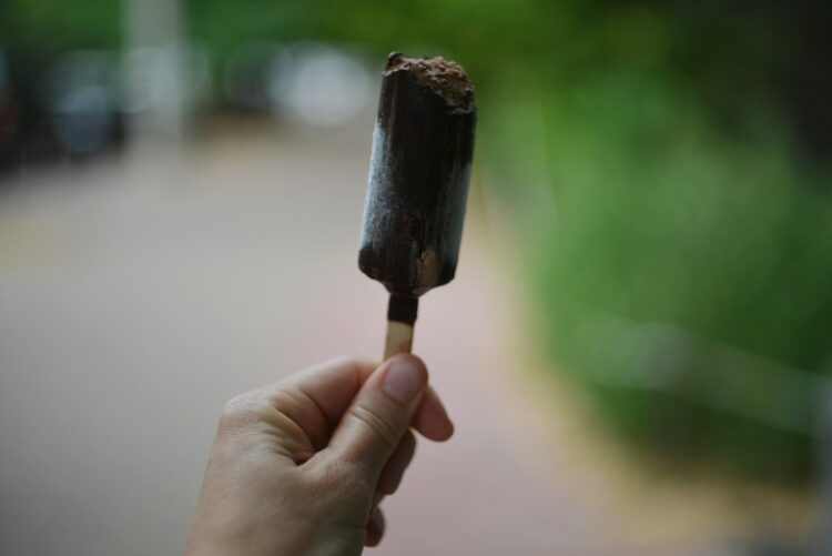 Hand holding a chocolate-covered popsicle