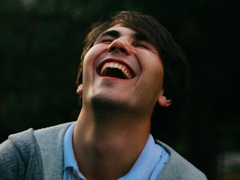 man in gray sweater smiling