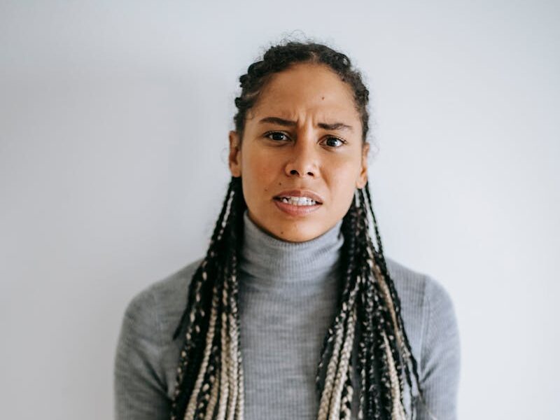 An adult black woman showing frustration and displeasure indoors with a gesture.