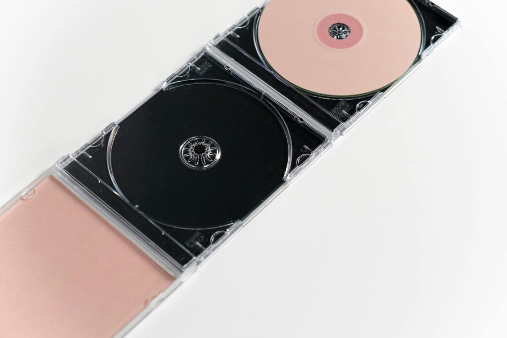 Artistic flat lay of open CD cases on a white surface, showcasing compact discs.