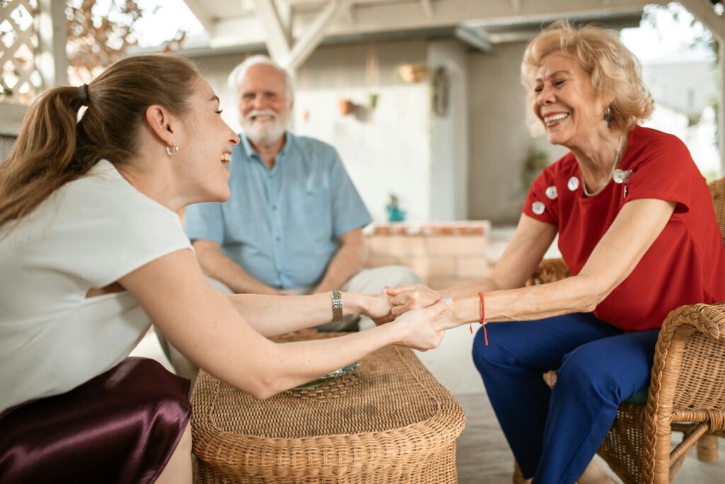 Three family members enjoying a happy conversation outside, sharing laughter and smiles.