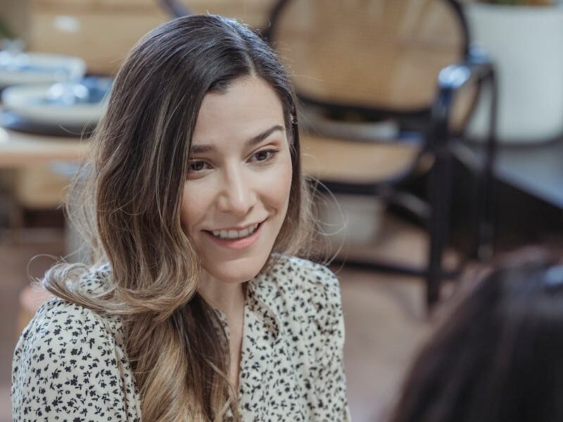 Two women engaging in a friendly discussion at a modern workspace.