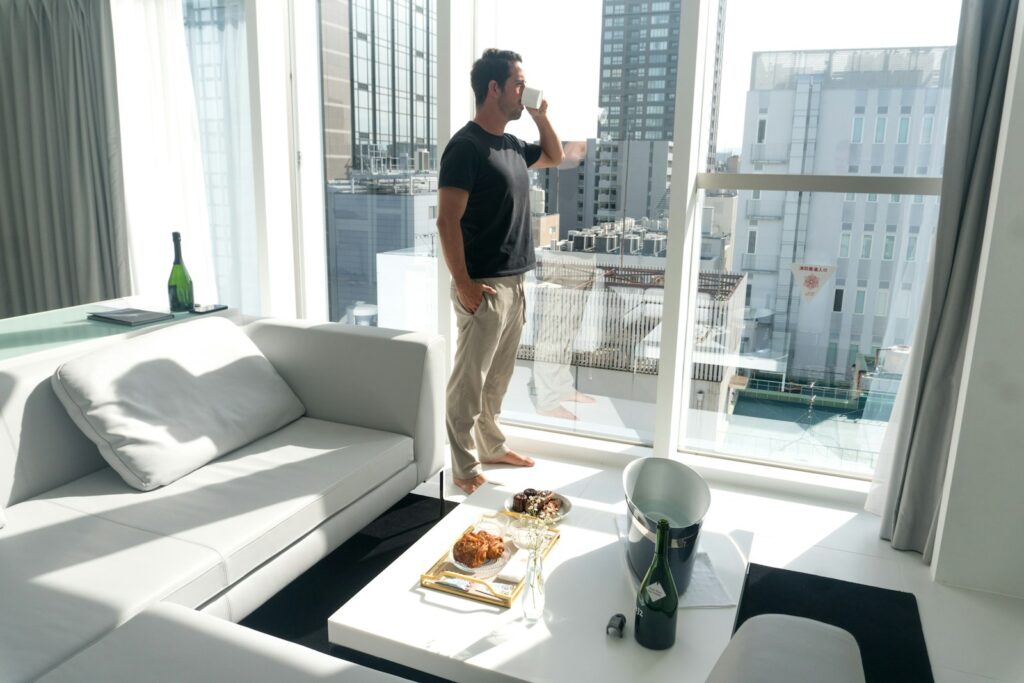 A man standing in a living room next to a window