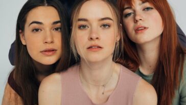 A diverse group of women posing elegantly in a studio setting.
