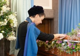 a woman arranging flowers in a wicker basket