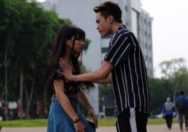 Teenage couple having a discussion in a city park.