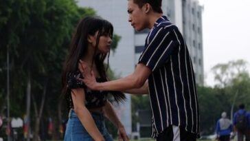 Teenage couple having a discussion in a city park.