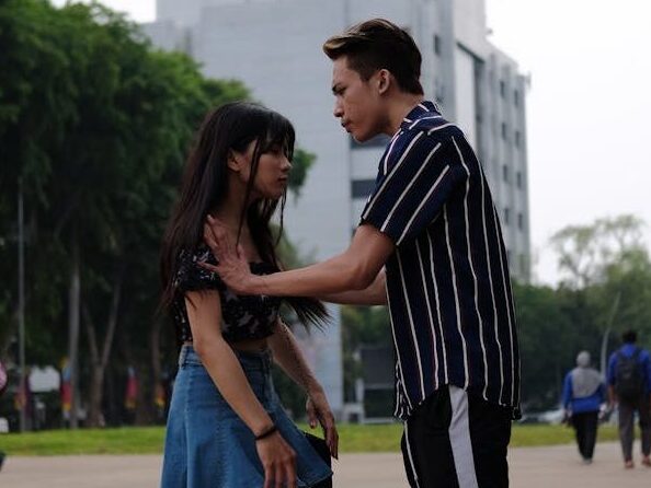 Teenage couple having a discussion in a city park.