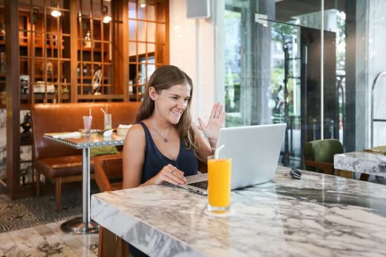 a woman sitting at a table using a laptop computer