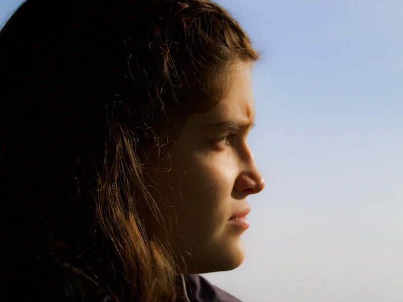 a woman looking out the window of a bus