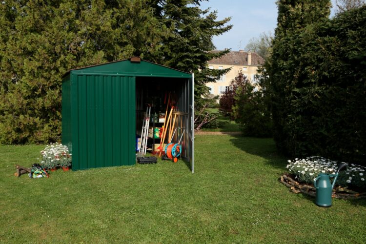 half opened green shed on grass near trees