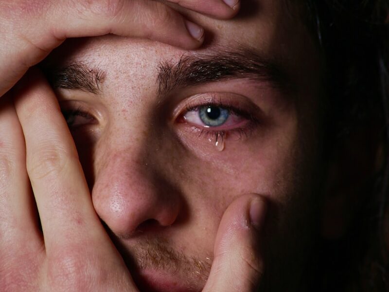a man holding his hands to his face