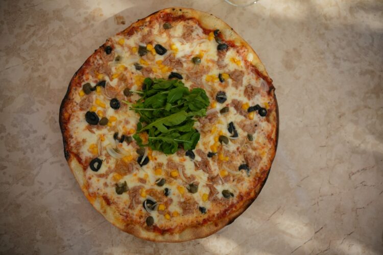 a pizza sitting on top of a table covered in toppings