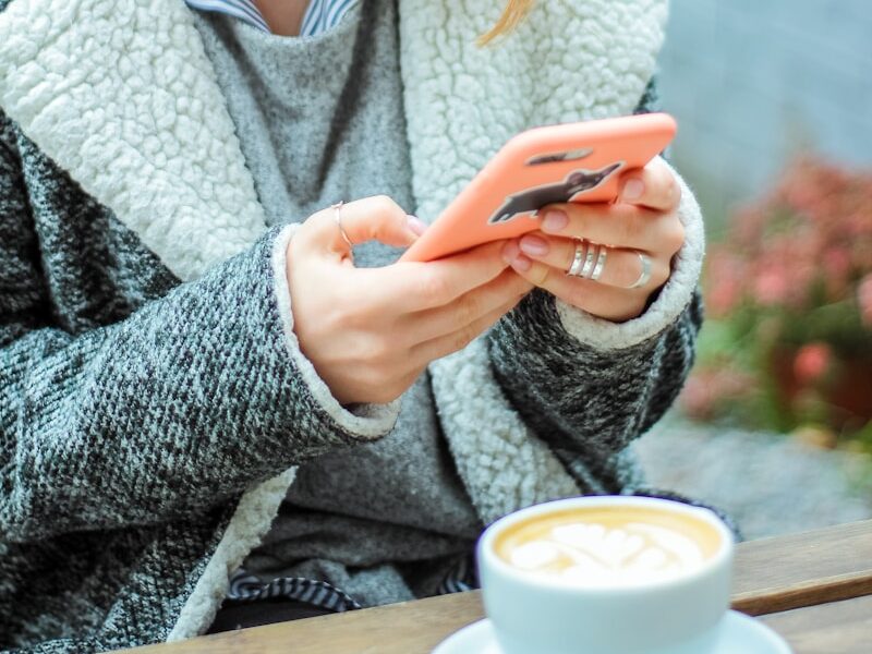 woman smiling while using her phone