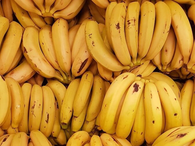 yellow banana fruit on brown wooden table
