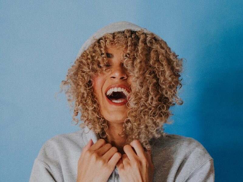 smiling woman wearing gray hoodie