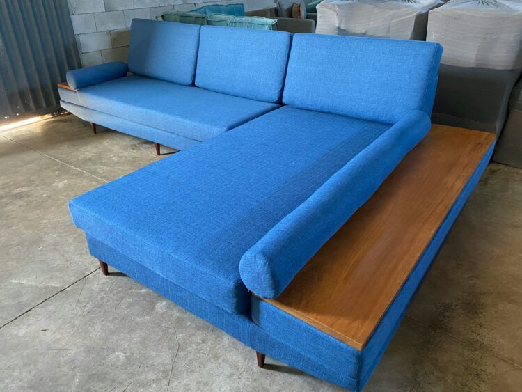a blue couch sitting on top of a wooden table