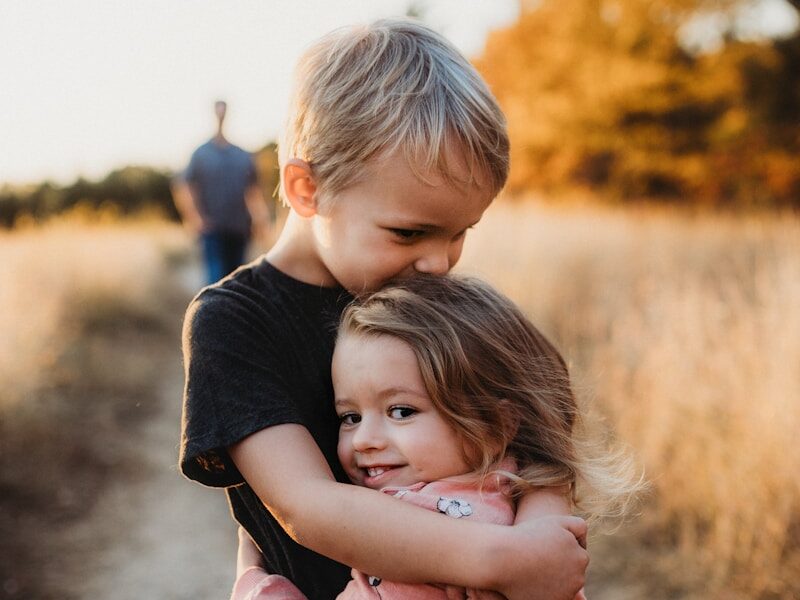 boy in black t-shirt hugging girl in red and white polka dot dress