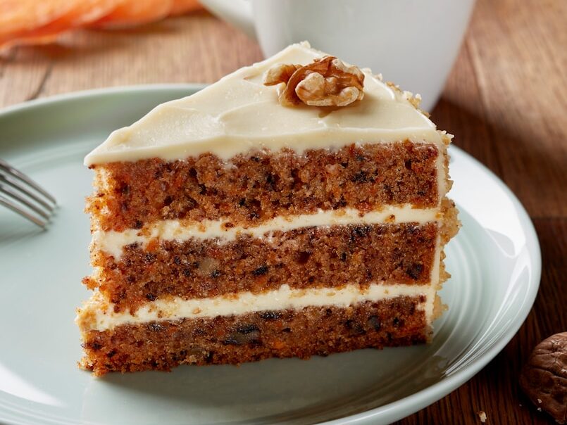 a piece of carrot cake on a plate with a fork