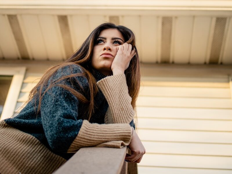 woman in blue denim jacket and brown scarf