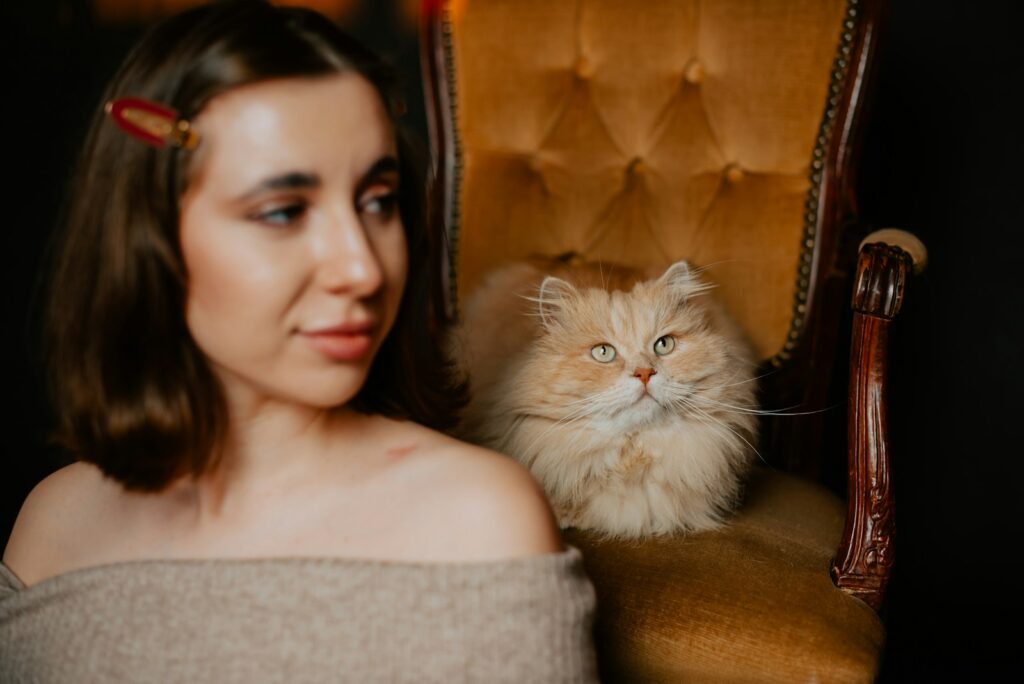 a woman sitting in a chair next to a cat