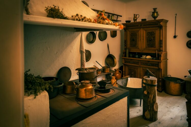 an old fashioned kitchen with pots and pans on the stove