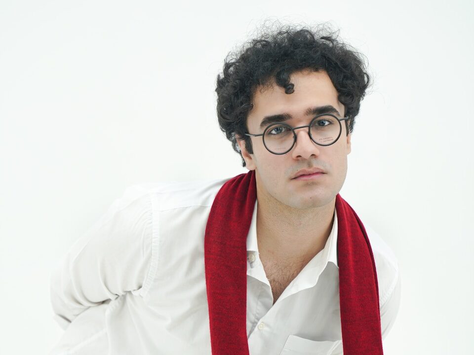 A man wearing glasses and a red scarf