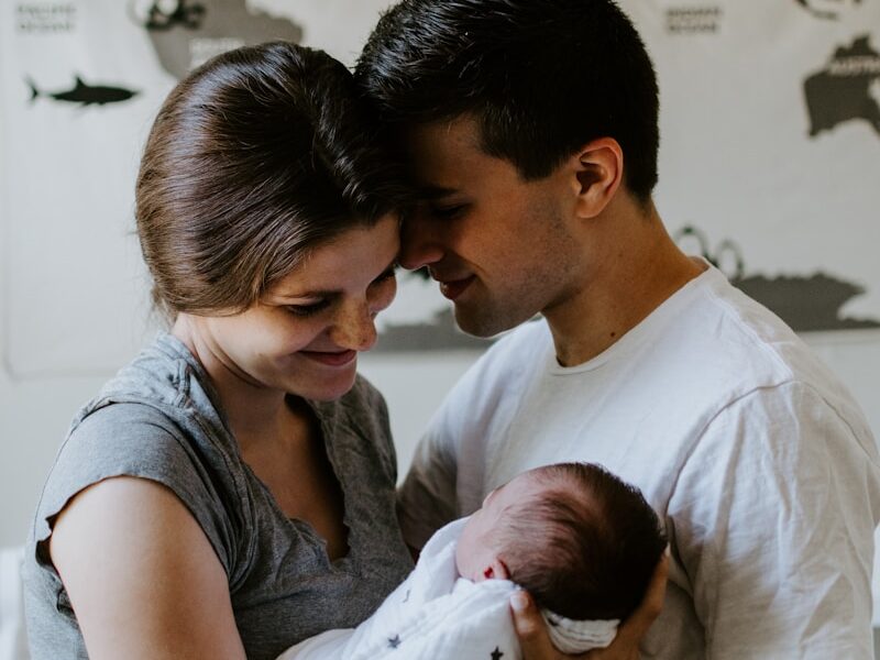 a man and woman holding a baby in their arms