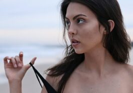woman about to take off her clothes at the beach