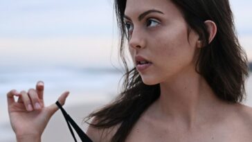 woman about to take off her clothes at the beach