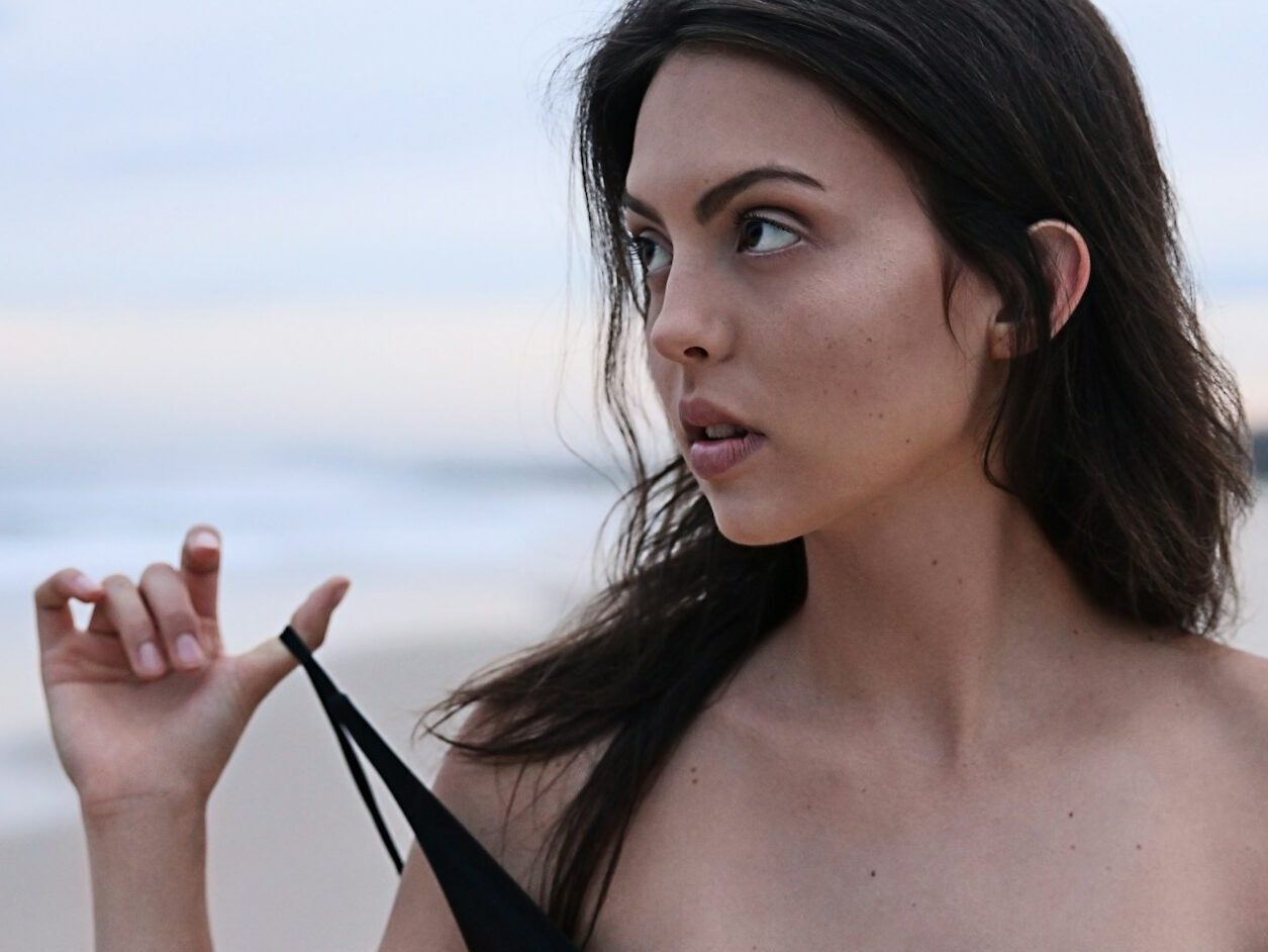 woman about to take off her clothes at the beach